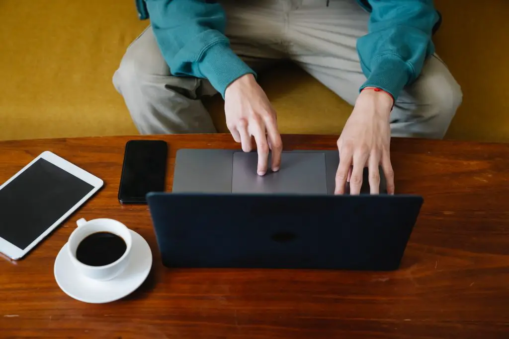 college student drinking coffee while typing