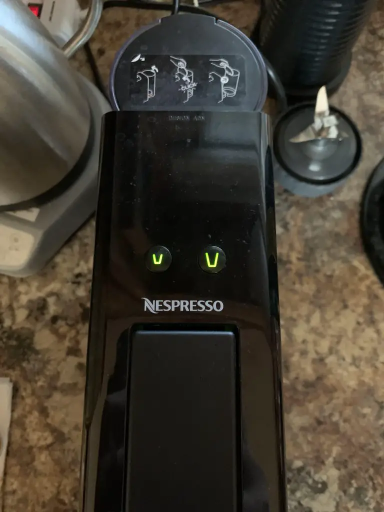 how to clean Nespresso essenza mini: press either the espresso or lungo button to run water to remove grinds